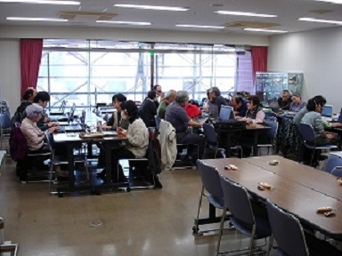 　講習室でサポーターとマンツーマンでパソコンを勉強をしている写真です。