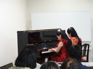 　木村姉妹のピアノの連弾(れんだん）演奏の写真です。